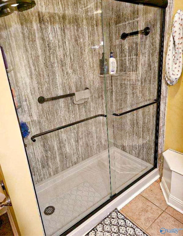 full bathroom with a shower stall and tile patterned flooring