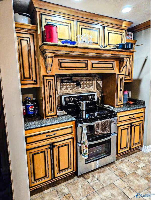 kitchen featuring stone finish flooring, baseboards, dark countertops, and double oven range