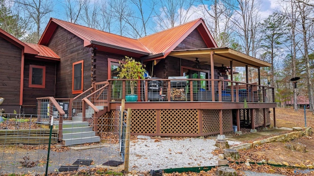 back of property with a wooden deck, metal roof, stairs, and ceiling fan