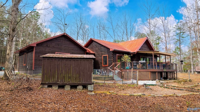 back of house with an outbuilding and metal roof