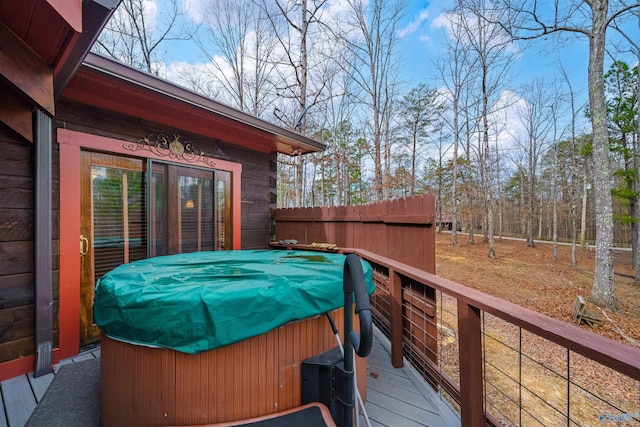 deck with a grill, a hot tub, and fence