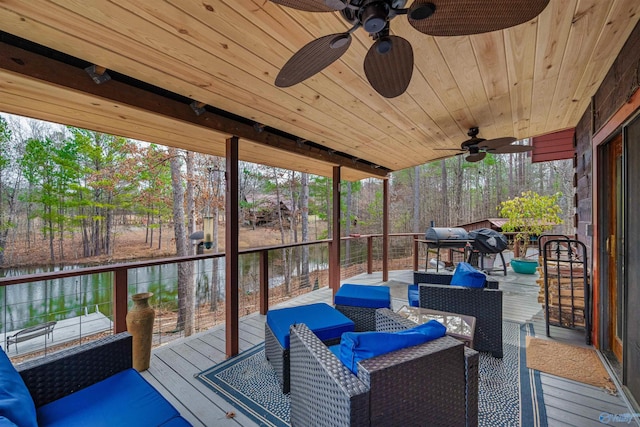 wooden deck featuring outdoor lounge area, ceiling fan, and a water view