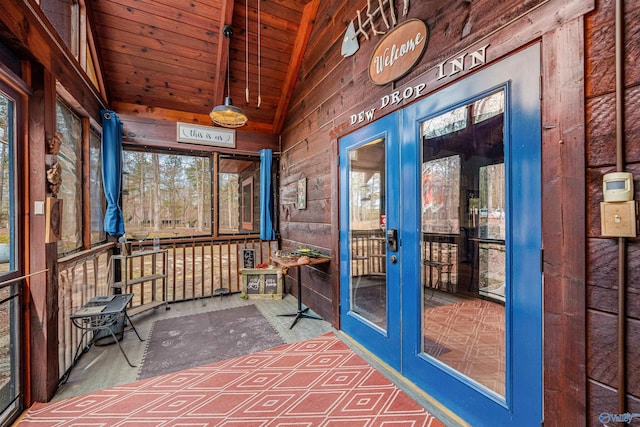 unfurnished sunroom featuring a wealth of natural light, french doors, and vaulted ceiling