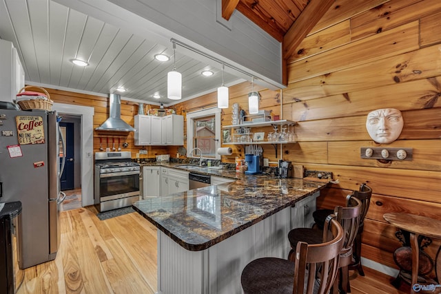 kitchen featuring a peninsula, a sink, stainless steel appliances, wooden ceiling, and exhaust hood