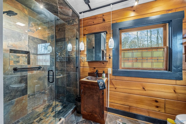 bathroom featuring vanity, a stall shower, and wood walls