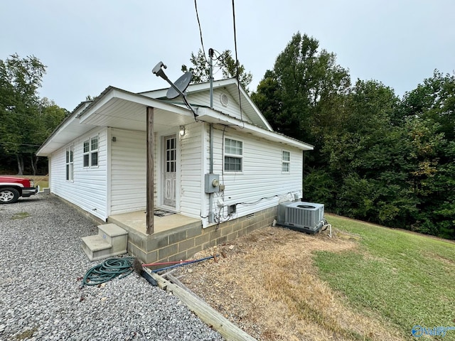 view of front of property with central AC unit and a front lawn