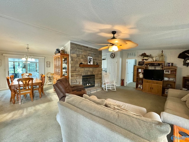 carpeted living room featuring a textured ceiling, ornamental molding, ceiling fan with notable chandelier, and a fireplace