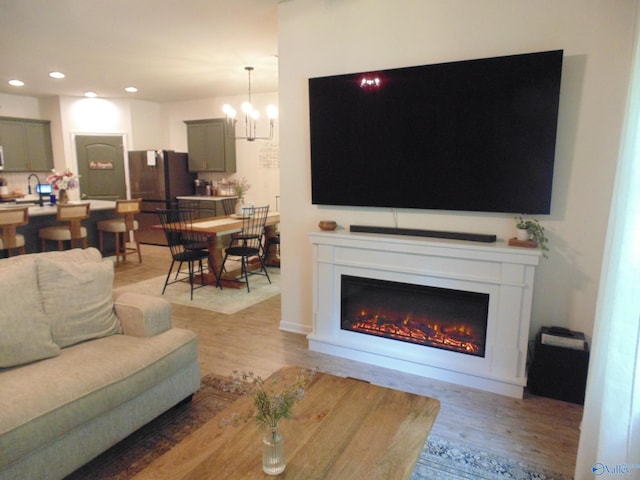 110 Oak Path Ln, Harvest, AL 35749 - living area with light wood-style flooring, a glass covered fireplace, recessed lighting, and a chandelier