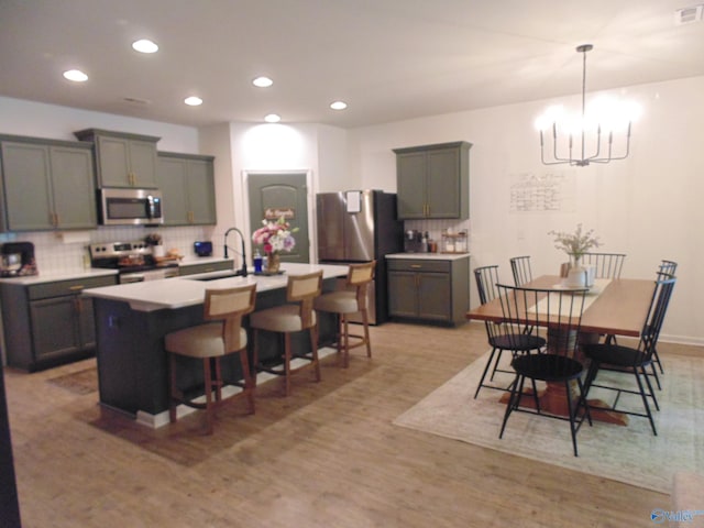 110 Oak Path Ln, Harvest, AL 35749 - kitchen featuring stainless steel appliances, a sink, a breakfast bar, decorative backsplash, and recessed lighting