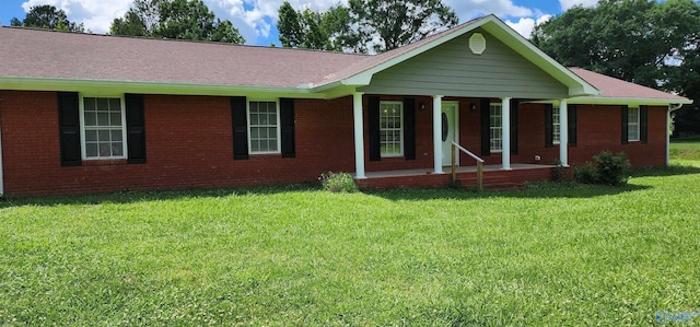 ranch-style home with a front lawn, a porch, brick siding, and a shingled roof