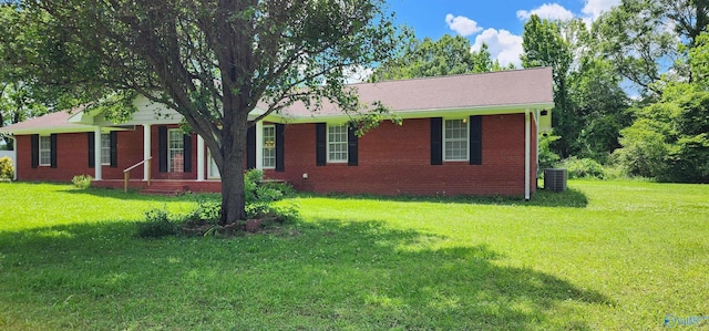 ranch-style home featuring a front lawn, brick siding, and central AC