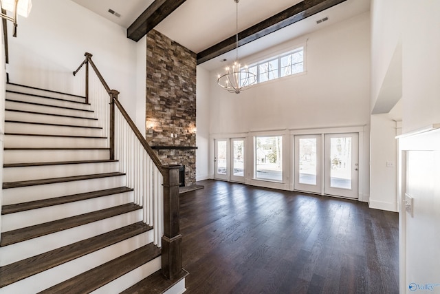 interior space featuring dark wood-style floors, stairway, a wealth of natural light, and beamed ceiling