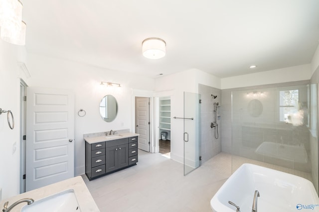 bathroom with a soaking tub, a shower stall, vanity, and a spacious closet