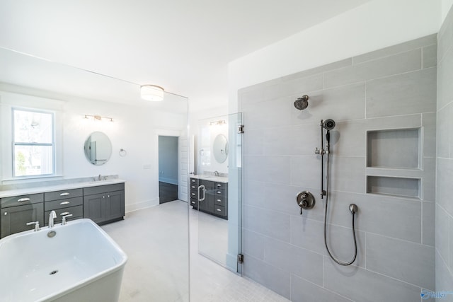 full bath with a stall shower, a freestanding bath, and vanity