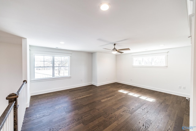 unfurnished room featuring plenty of natural light, baseboards, and dark wood-style flooring