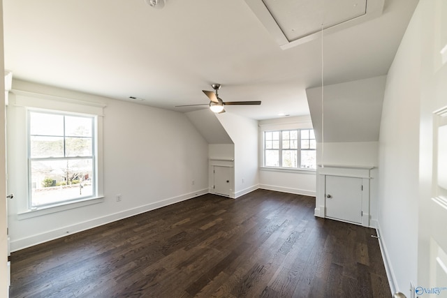 bonus room featuring dark wood-type flooring, visible vents, baseboards, vaulted ceiling, and attic access