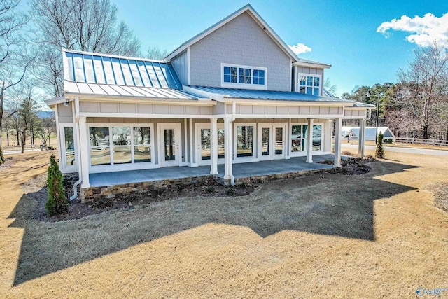 rear view of property with metal roof, french doors, board and batten siding, a standing seam roof, and a patio area