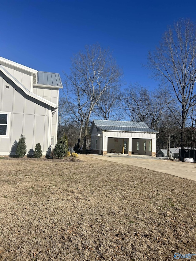 exterior space with board and batten siding, a standing seam roof, a yard, and metal roof