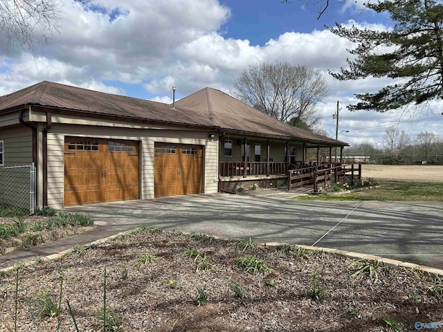 exterior space featuring metal roof, driveway, and an attached garage