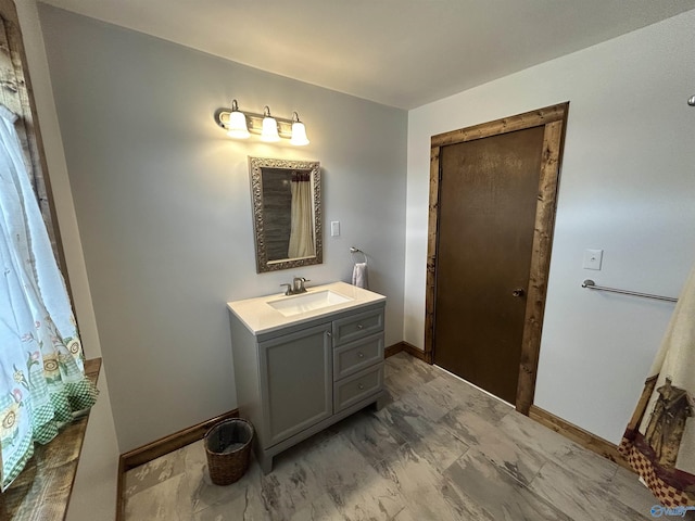 bathroom featuring marble finish floor, vanity, and baseboards