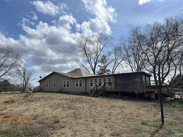 rear view of house with a yard and a wooden deck