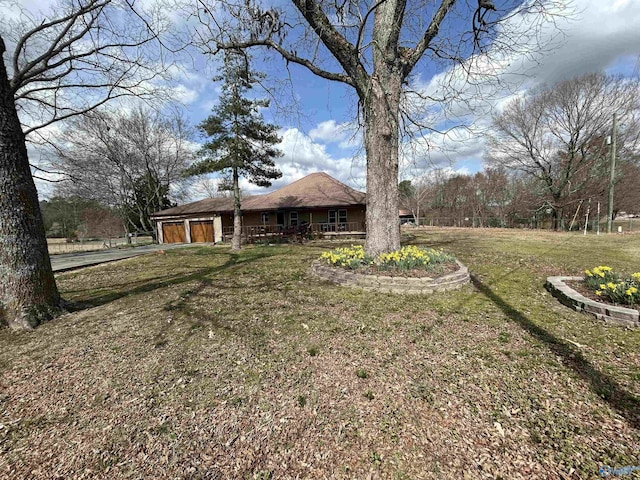 view of yard with covered porch and an attached garage