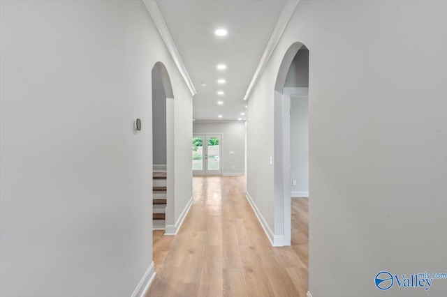 corridor featuring crown molding and light hardwood / wood-style flooring