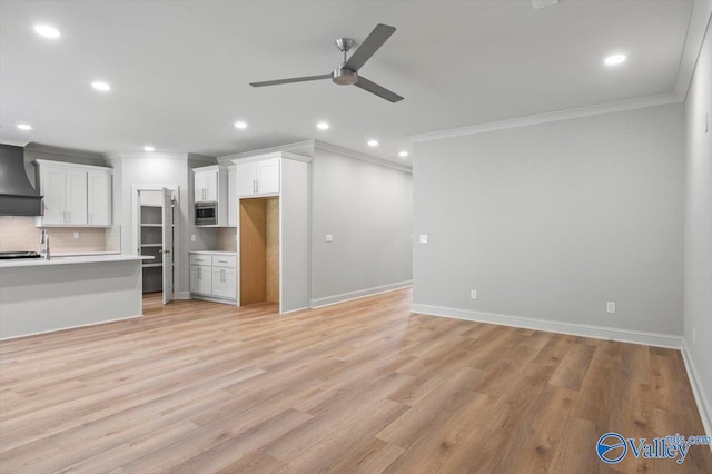 unfurnished living room featuring ceiling fan, crown molding, and light hardwood / wood-style flooring