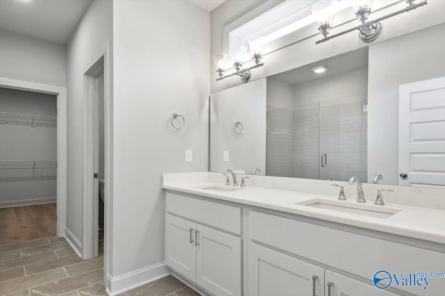 bathroom with a shower with shower door, vanity, and hardwood / wood-style flooring