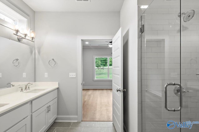 bathroom with hardwood / wood-style floors, walk in shower, ceiling fan, and vanity