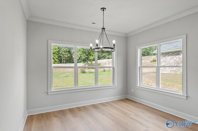 unfurnished dining area featuring light hardwood / wood-style flooring, crown molding, a notable chandelier, and a healthy amount of sunlight