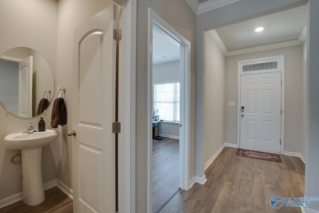 entryway featuring ornamental molding, wood finished floors, and baseboards