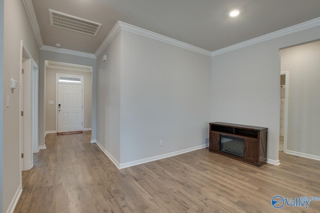 hallway with baseboards, visible vents, wood finished floors, and ornamental molding