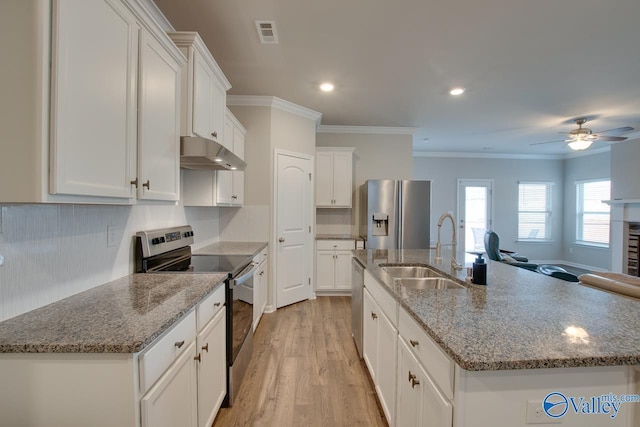 kitchen featuring appliances with stainless steel finishes, white cabinets, a sink, and under cabinet range hood