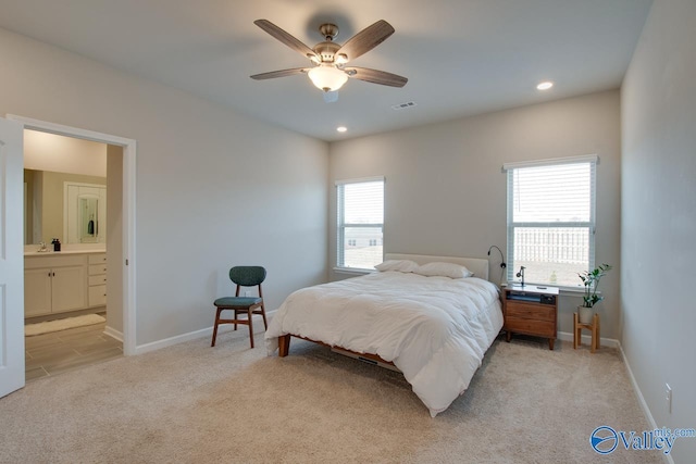 bedroom with recessed lighting, light carpet, connected bathroom, and baseboards