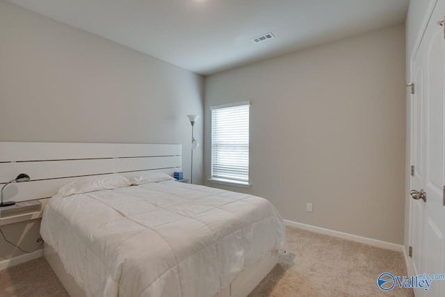 carpeted bedroom featuring visible vents and baseboards