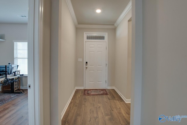 entryway with visible vents, crown molding, baseboards, and wood finished floors