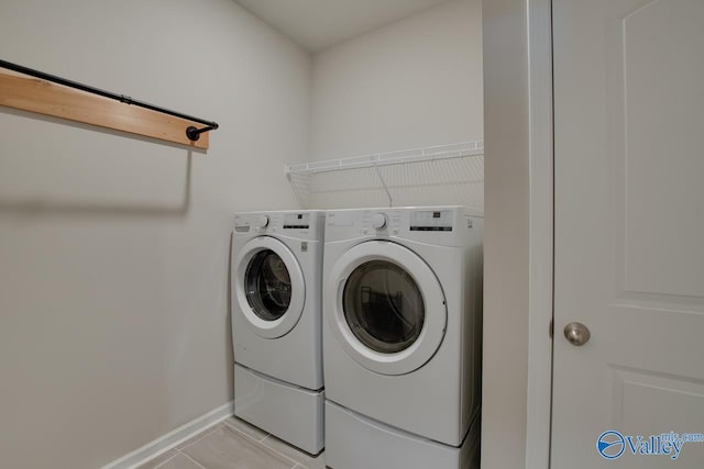 laundry room featuring laundry area, baseboards, and separate washer and dryer