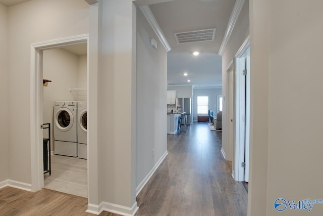 hallway with recessed lighting, wood finished floors, visible vents, independent washer and dryer, and crown molding