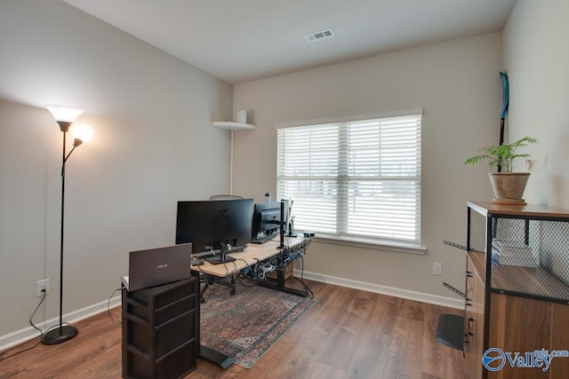 office featuring wood finished floors, visible vents, and baseboards