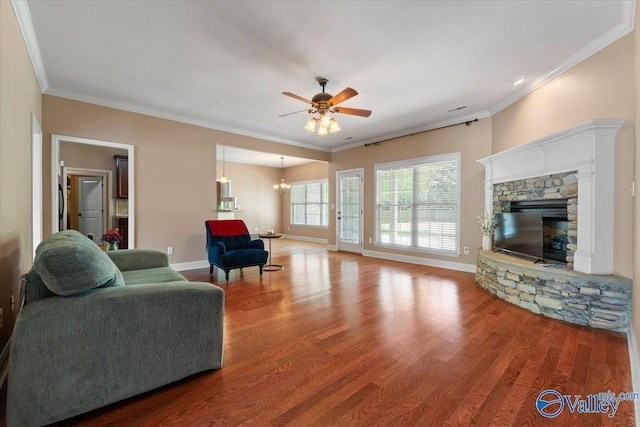living area with ornamental molding, ceiling fan, wood finished floors, and baseboards
