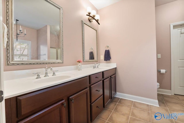 bathroom featuring double vanity, baseboards, toilet, and tile patterned floors