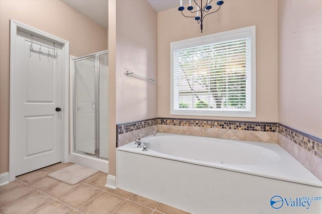bathroom featuring tile patterned flooring, a shower stall, and a bath