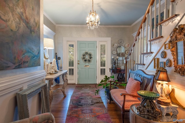 entrance foyer with a chandelier, stairway, dark wood finished floors, and crown molding