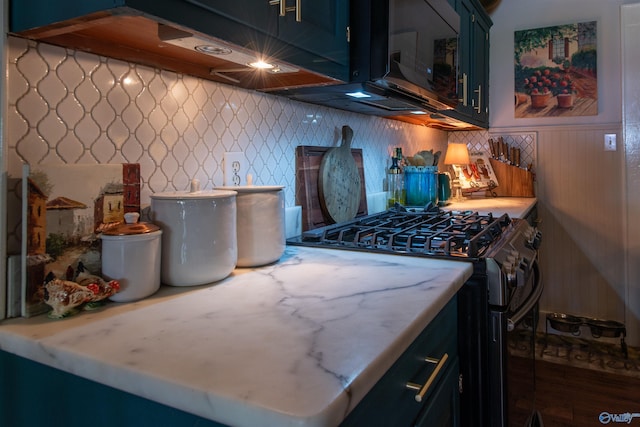 kitchen featuring glass insert cabinets, light countertops, stainless steel gas stove, and blue cabinetry