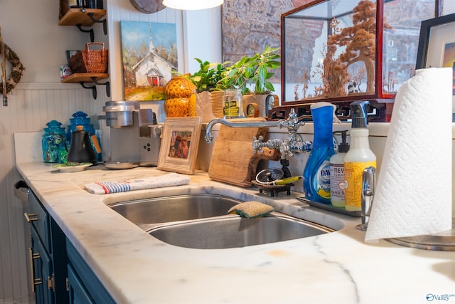 kitchen with light countertops, blue cabinetry, and a sink