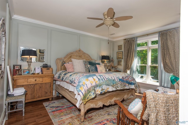 bedroom featuring crown molding, dark wood-style flooring, a decorative wall, and a ceiling fan