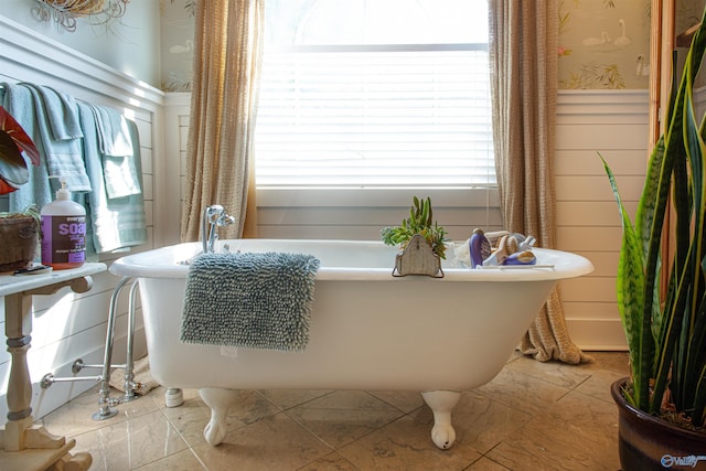 full bath featuring a soaking tub, wainscoting, and wallpapered walls