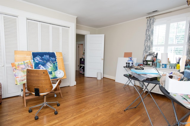 home office with ornamental molding, wood finished floors, visible vents, and baseboards