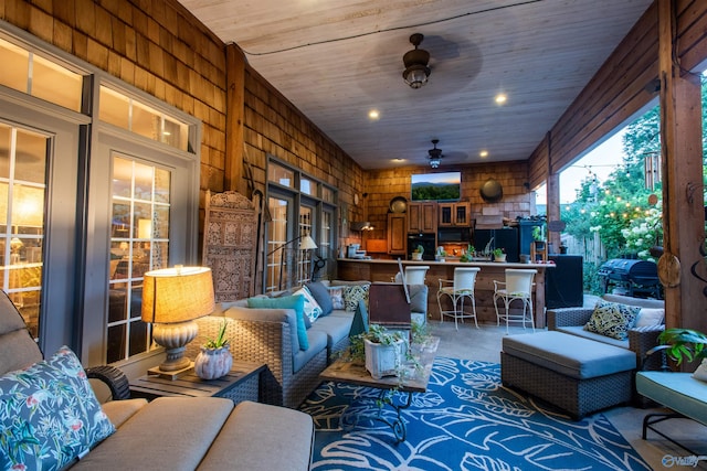 interior space featuring outdoor dry bar, ceiling fan, grilling area, and outdoor lounge area